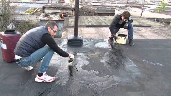 Мужчины работают на крыше гаража